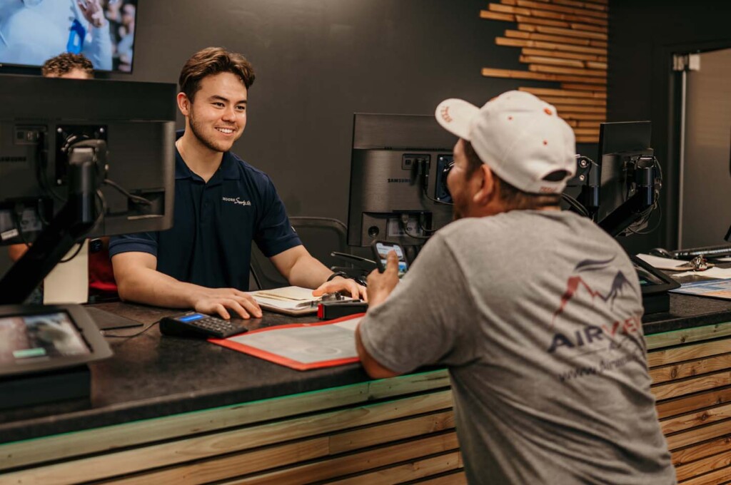 Smiling plumbing counter teammate helping a customer